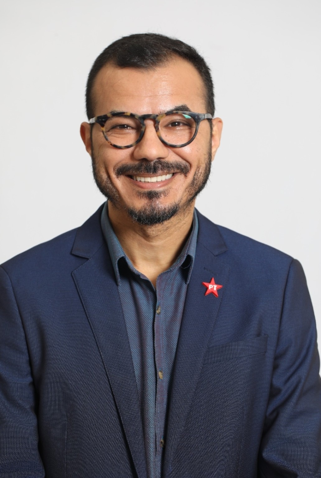 Psicólogo Marcos Vargas sorrindo, de terno azul